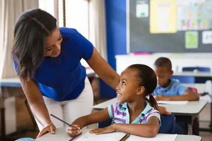 Teacher helping a student at her desk